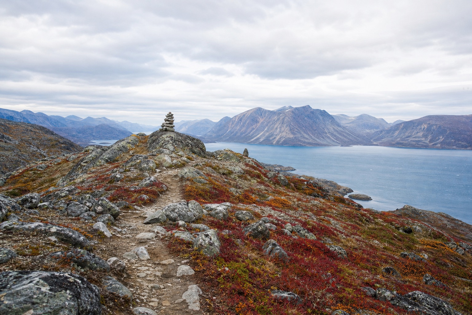 Vandrer med rygsæk i tundraterræn på Arctic Circle Trail