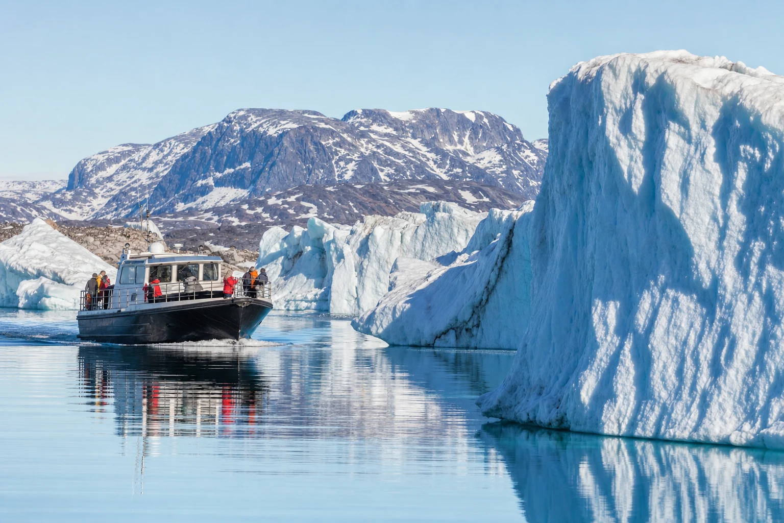 Expedition boat sailing across calm Arctic water near Ilulissat